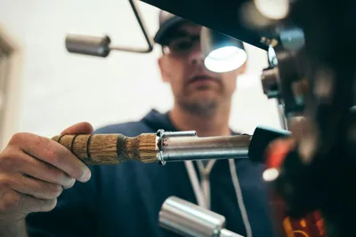 A focused mechanic working on a component at the workbench in an auto shop