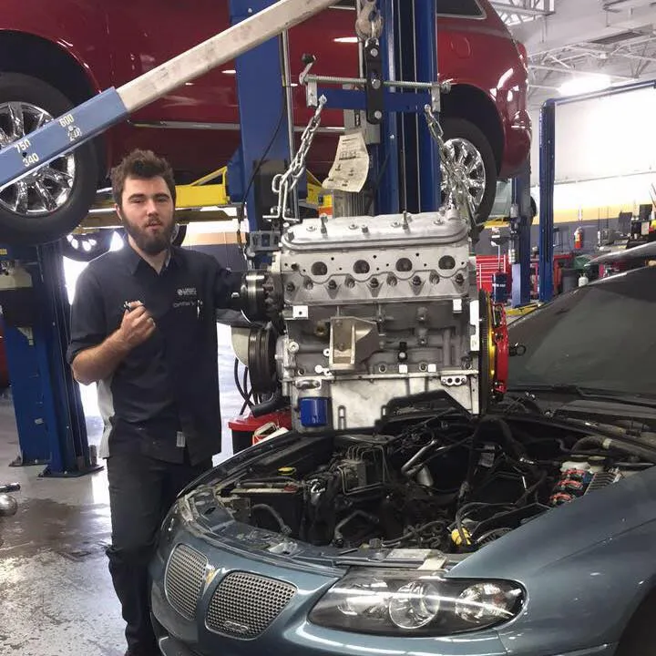 Javen Coughlin, owner and head mechanic of Floorjack Auto Repair, pulling an engine in the shop